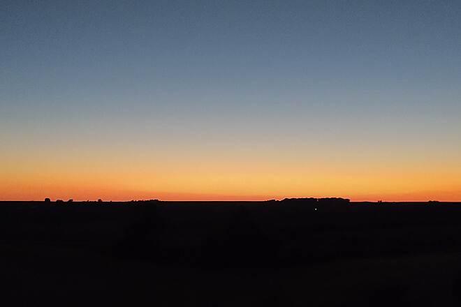 A simple sunset with a thin orange glow along the horizon beneath a darkening blue sky.